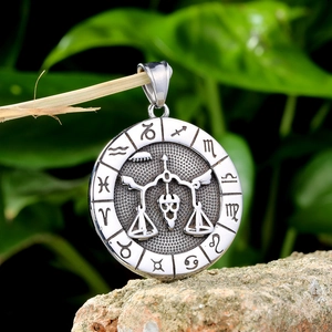 Close-up of silver Libra zodiac pendant with astrological symbols on stainless steel necklace