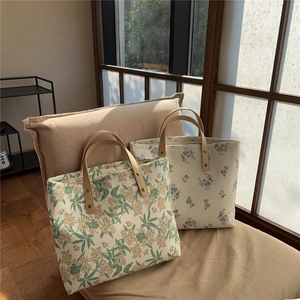 Detailed close-up of quilted floral tote bags with leather handles and metal rivets
