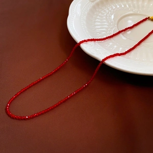 Vue détaillée des perles de cristal rouge facettées du choker avec fermoir doré
