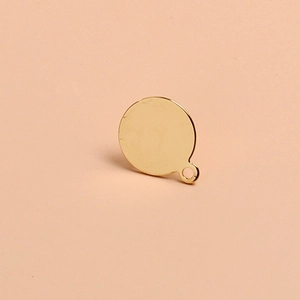 Macro shot of circular gold metal pendant charm for DIY earring and jewelry making