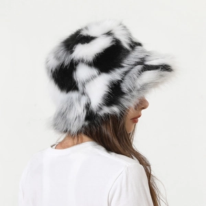 Side view of fluffy faux fur bucket hat with black and white cow print texture