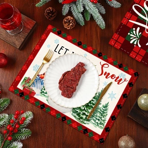 Festive Christmas table mat with Let It Snow print on wooden table with holiday decor