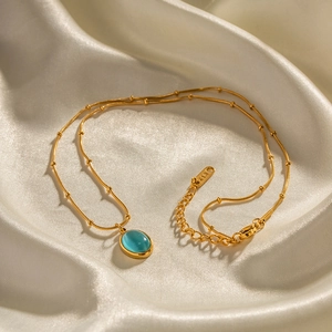 Elegant 18K gold-plated snake chain necklace with a stunning blue cat-eye stone pendant