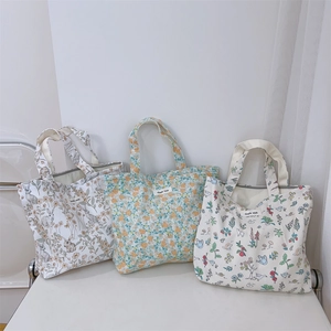 Three assorted canvas handbags featuring vintage floral and rabbit prints with zip closures