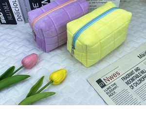 Detail of purple and yellow quilted velvet stationery pouches in a soft ins-style setting