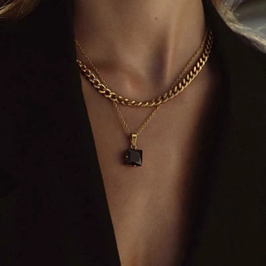 Collana a doppio strato in acciaio al titanio dorato con pendente in zircone AAA su modella