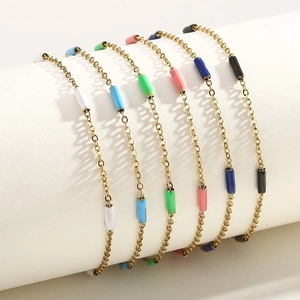 Détail de perles colorées sur une chaîne en acier doré enroulée sur un support