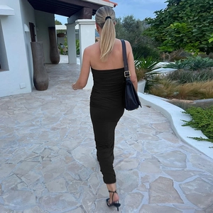 Detail view of the ruched side texture on this black bodycon strapless maxi dress
