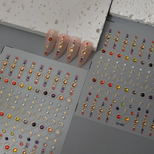 Celestial nail art stickers with gold sun moon stars and colorful rhinestones
