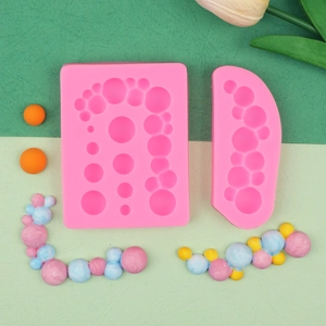 Roze siliconen bellenmatrijs voor fondant met kleurrijke afgewerkte decoraties in beeld