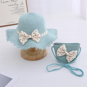 Detail of light blue straw sun hat and matching bag with beige polka dot bows