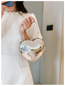 Detail view of heart-shaped acrylic silver mirror handbag with sleek chain strap
