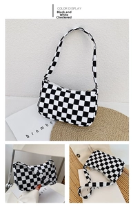 Detail of black and white checkered canvas shoulder bag with golden zipper and strap