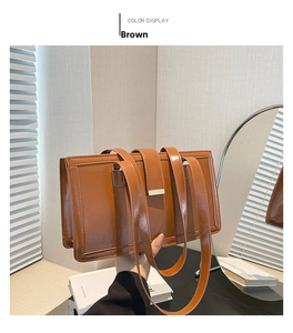 Detail of a brown vintage rectangular shoulder bag with golden buckle in a home setting