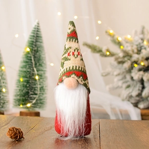 Detail van kerstkabouter met rode gebreide muts en witte baard op houten tafel