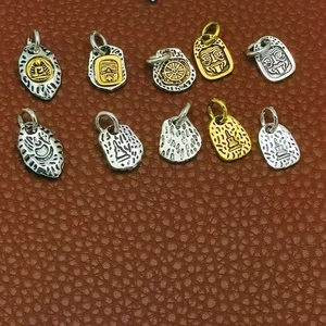 Set of 10 vintage alloy pendants with Tibetan style religious embossed patterns in gold and silver