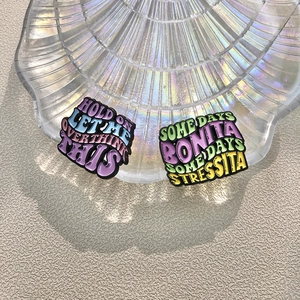 Creative colorful enamel pins featuring funny quotes on a pearlescent shell tray
