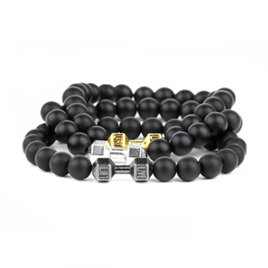 Detail of beaded bracelets featuring gold, silver and gunblack dumbbell charms with LIFT LIVE