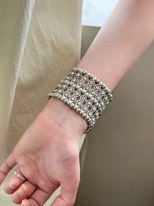 Gros plan du large bracelet argenté vintage avec diamants sur le poignet féminin