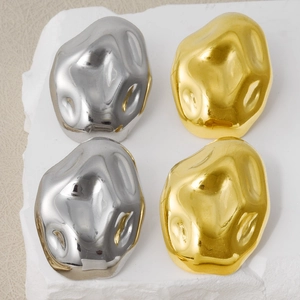 Macro detail of irregular liquid metal earrings in 18k gold and silver mirror finish