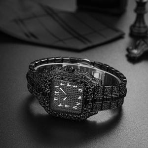 Detailed view of luxury iced-out black square watch with Arabic numerals on dark desk