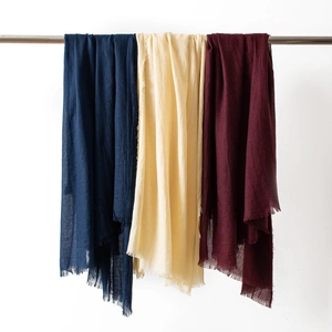 Detailed shot of lightweight cotton linen scarves with fringe in navy, beige, and wine red