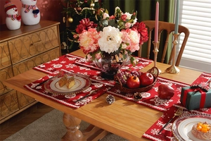 Detailed view of red Christmas table runner with white snowflake and ornament patterns