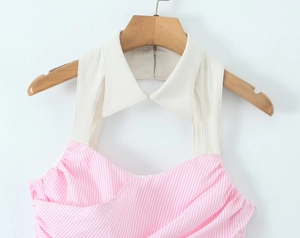 Detail of pink striped halter top with white lapel collar and button on wooden hanger