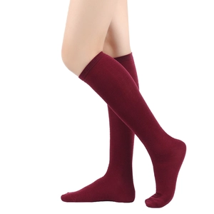 Detail of burgundy knee-high socks with triple stripes shown on model leg