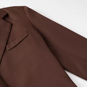 Détail du revers marron et de la texture tissée d'un blazer long décontracté