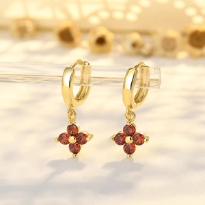Goldene Ohrhänger mit Kleeblatt-Blumenanhängern und tiefroten Zirkonia-Kristallen