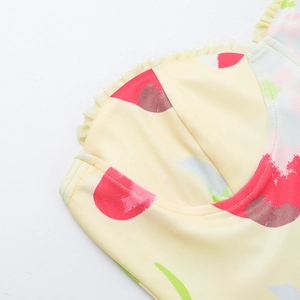 Gros plan du haut de bikini à imprimé floral jaune avec volants et coutures précises