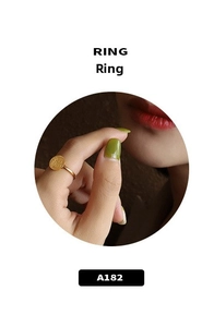 Close-up of a 18K gold plated titanium ring with a lucky Fu character pendant