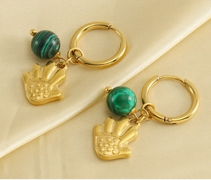 Détail de boucles d'oreilles Hamsa plaquées or 18k avec perles turquoise sur soie