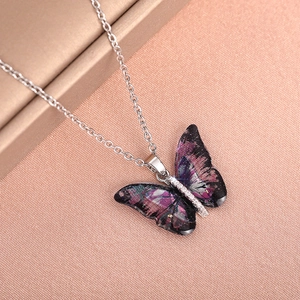 Macro detail of acrylic butterfly pendant with glitter starry texture and zircon inlay