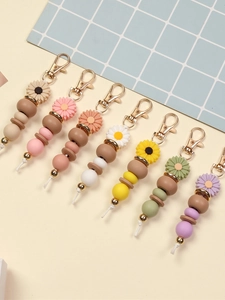 Flat lay of seven colorful daisy beaded keychains with silicone beads and metal clasps