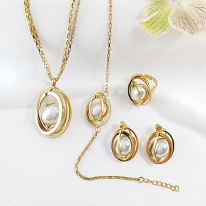 Detail of gold geometric jewelry set with white pearls including necklace and rings