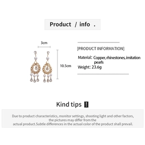 Detailed view of vintage gold hollow teardrop earrings with pearls and crystals