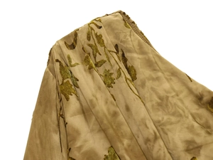 Macro view of gold velvet flocking fabric with floral patterns and satin sheen