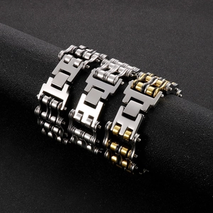 Men's titanium steel bicycle chain bracelet in silver and gold tones on a black stand