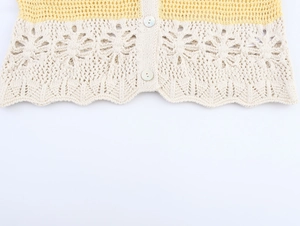 Detail of yellow and white crochet knit top with floral pattern and pearl buttons