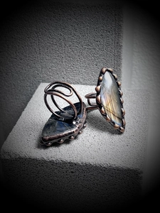 Detailed view of handmade copper wire-wrapped rings with natural blue-green labradorite