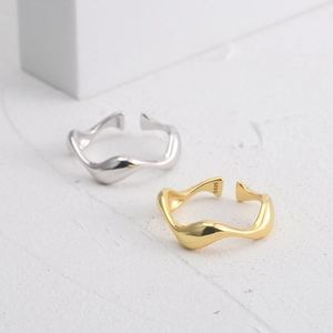 Macro detail of wave shaped S925 sterling silver open rings in gold and silver finish
