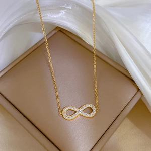 Detail of gold infinity pendant with small diamonds on a khaki jewelry box background