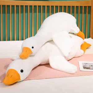 Soft cartoon white goose plush pillow set in two sizes on a cozy bedroom background