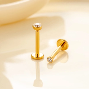 Two gold-plated titanium labret studs with clear round zircon stones and flat backs