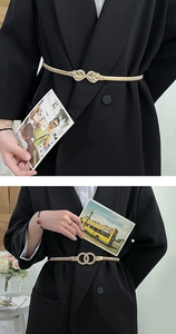 Detail of golden elastic chain belts with bow and interlocking ring buckles on a blazer