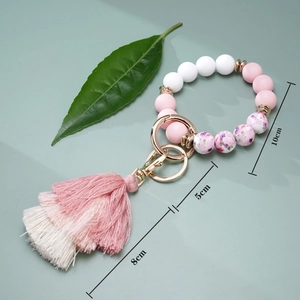 Silicone beaded keychain bracelet with floral beads and pink tassel showing dimensions
