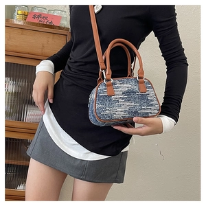 Detail of blue denim crossbody bag with white sequins and brown leather straps