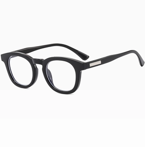 Detail view of round black retro sunglasses frame with textured metal temple accents